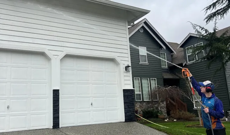 Seattle ProWash technician washing house siding